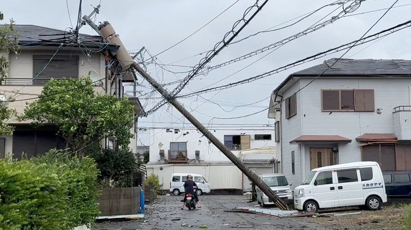 © Reuters. A person rides through a fallen pole following Typhoon Shanshan in Miyazaki, Japan, August 29, 2024 in this screengrab taken from a social media video. BAKUTENMAN/@bakuteman_8910/via REUTERS  