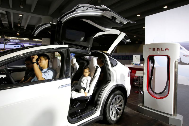 &copy; Reuters. FILE PHOTO: Visitors experience Tesla Model X at Auto Guangzhou in Guangzhou, China November 17, 2017.      REUTERS/Bobby Yip/File Photo