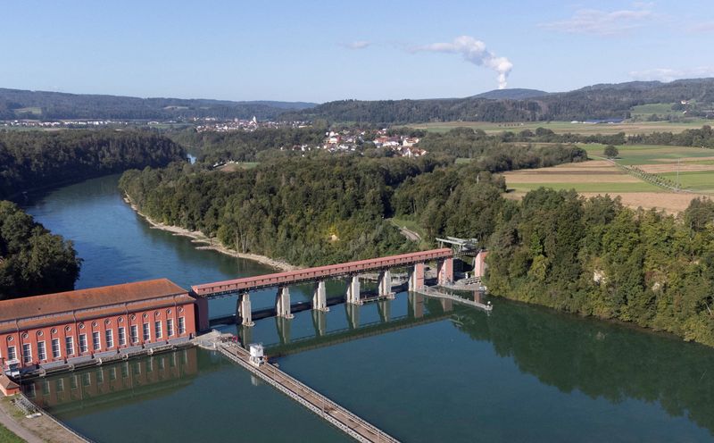 © Reuters. FILE PHOTO: Steam rises from the cooling tower of the KKW Leibstadt nuclear power plant of Swiss energy company Kernkraftwerk Leibstadt AG behind the Eglisau hydropower plant of Swiss company Axpo enrgy and the Rhine river in Rheinsfelden, Switzerland, September 20, 2022. REUTERS/Arnd WIegmann / Photo file