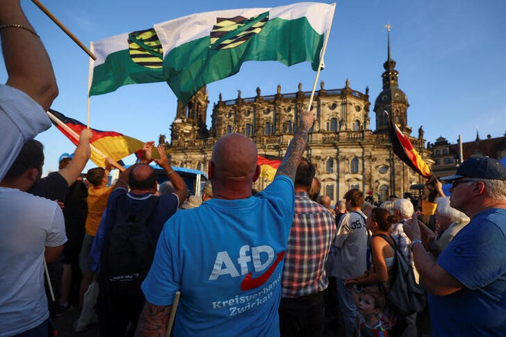 © Reuters. People wave flags during Germany's Alternative for Germany (AfD) campaign event for the Saxony state elections in Dresden, Germany, August 29, 2024. REUTERS/Lisi Niesner