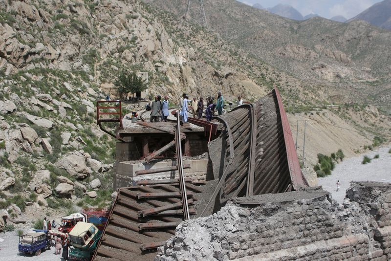 © Reuters. FILE PHOTO: Workers stand on damaged railway tracks as they repair them, a day after separatist militants conducted deadly attacks, in Bolan district of Pakistan's restive province of Balochistan, Pakistan August 27, 2024. REUTERS/Naseer Ahmed/File Photo