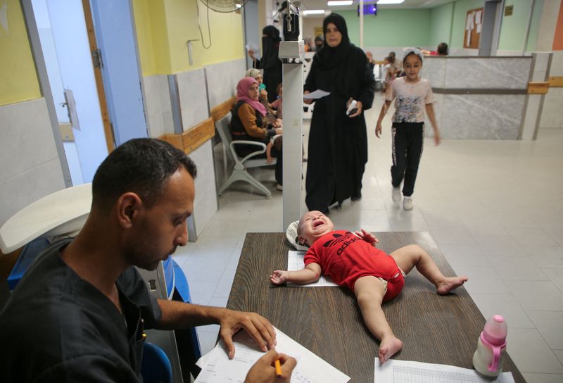 © Reuters. A Palestinian child is examined by a doctor at Nasser Hospital as United Nations officials are preparing to launch a polio vaccination campaign on Sunday that will rely on a series of limited pauses in fighting between Israeli forces and Hamas, in Khan Younis, in the southern Gaza Strip, August 30, 2024. REUTERS/Hatem Khaled