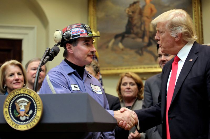 © Reuters. FILE PHOTO: Michael Nelson, a coal miner,shakes hands with then-U.S. President Donald Trump as Trump prepares to sign Resolution 38, which nullfies the 