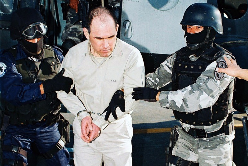 © Reuters. FILE PHOTO: Suspected Gulf cartel boss Osiel Cardenas (C) is escorted by members of Mexico's Federal Agency of Investigations in Mexico City in this handout photo taken January 20, 2007.  REUTERS/Attorney General's office/Handout/File Photo