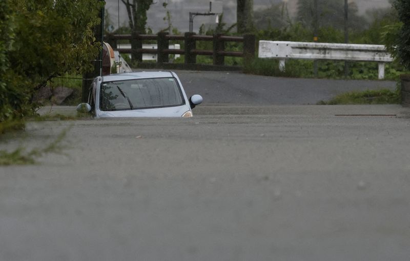 © Reuters. FILE PHOTO: A car is submerged at a flooded area due to heavy rains from Typhoon Shanshan in Yufu, Oita Prefecture, southwestern Japan, August 29, 2024, in this photo taken by Kyodo. Mandatory credit Kyodo/via REUTERS /File Photo