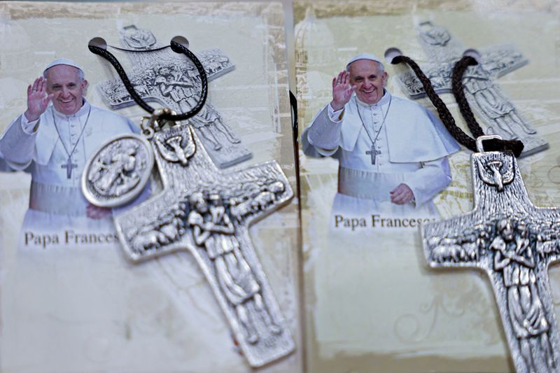 © Reuters. Photographs of Pope Francis are displayed beside crosses at the Avila store ahead of his visit, in Jakarta, Indonesia, August 31, 2024. REUTERS/Ajeng Dinar Ulfiana