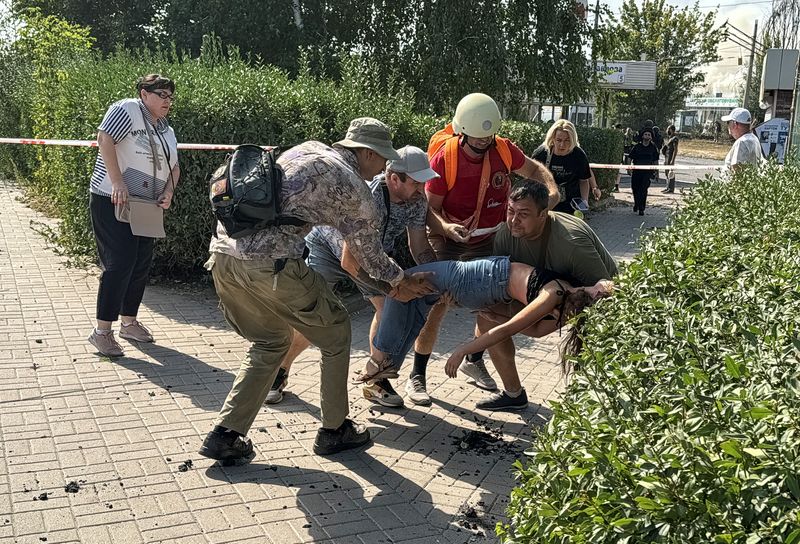 © Reuters. Volunteers carry a wounded resident, Kharkiv, September 1, 2024. REUTERS/Vitalii Hnidyi