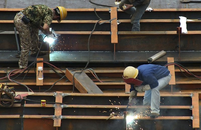 © Reuters. FILE PHOTO: Workers weld steel frames as they work at a shipyard in Yichang, Hubei province September 14, 2014. REUTERS/Stringer/File Photo