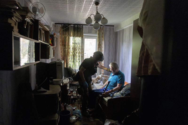 © Reuters. FILE PHOTO: A volunteer of East SOS assists resident Andrii Ostorozhnyi who is evacuating his home because of Russian advances, amid Russia's attack on Ukraine, in Selydove near Pokrovsk, Ukraine, August 22, 2024. REUTERS/Thomas Peter/File photo