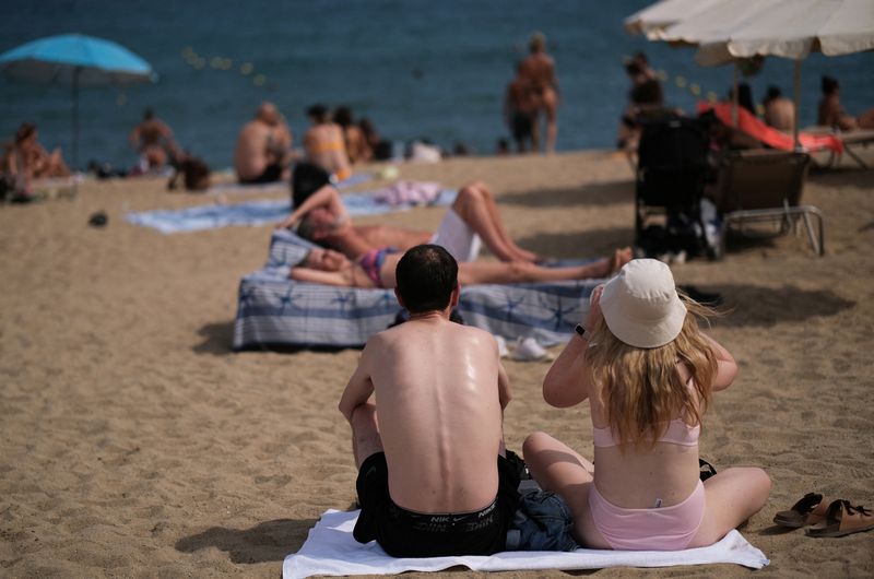 &copy; Reuters. FILE PHOTO: Tourists enjoy the Mediterranean Sea at Barceloneta beach in Barcelona, Spain August 25, 2024. REUTERS/Nacho Doce/File Photo