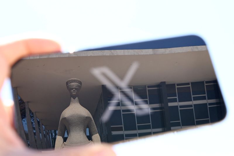 © Reuters. The logo of social media platform X is seen on a mobile phone next to a reflection of Brazil's Supreme Court in this illustration taken August 30, 2024, in Brasilia, Brazil.   REUTERS/Ueslei Marcelino/File Photo