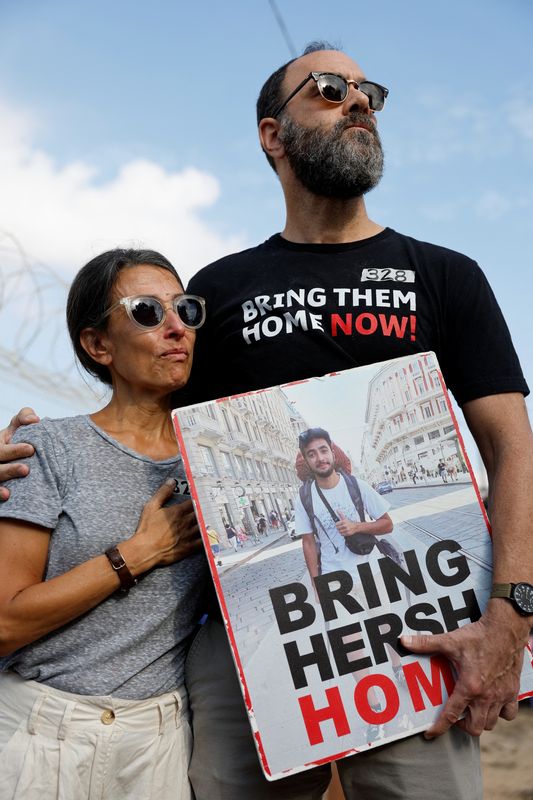 &copy; Reuters. Jon Polin e Rachel Goldberg-Polin, pais do refém Hersh Goldberg, mostram pôster com a imagem do filho no dia em que familiares e apoiadores usam alto-falantes gigantes para chamar seus entes queridos cativos através da fronteira de Israel com Gazan29/0