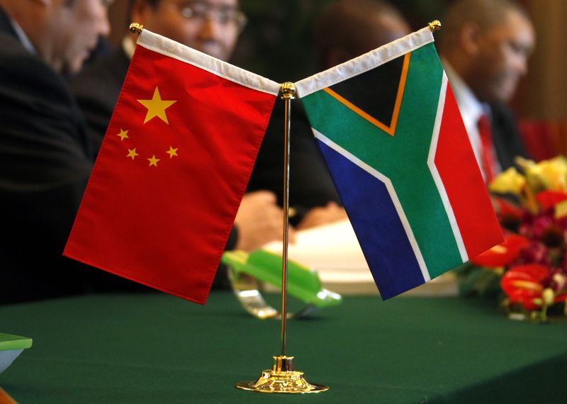 © Reuters. The South African and Chinese national flags lie on a table as businessmen sign contracts during the China-South Africa Business Forum in Beijing on August 24, 2010. REUTERS/David Gray/ File photo