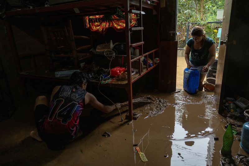 © Reuters. Residents clean the mud out of their home after it was flooded due to heavy rains brought by Tropical storm Yagi, locally known as Enteng, in Baras, Rizal province, Philippines, September 2, 2024. REUTERS/Eloisa Lopez