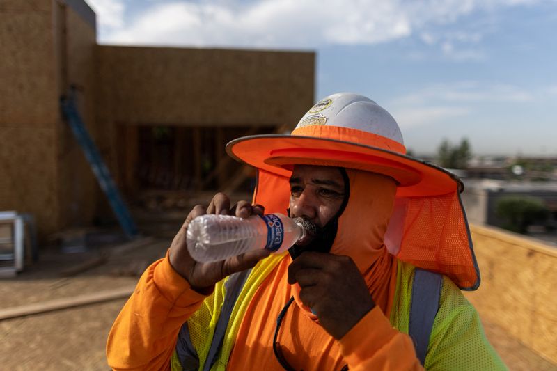 © Reuters. FILE PHOTO: A construction worker drink cold water during a heat wave in Scottsdale, at the Phoenix metro area, Arizona, U.S., July 28, 2023. REUTERS/Carlos Barria/File Photo