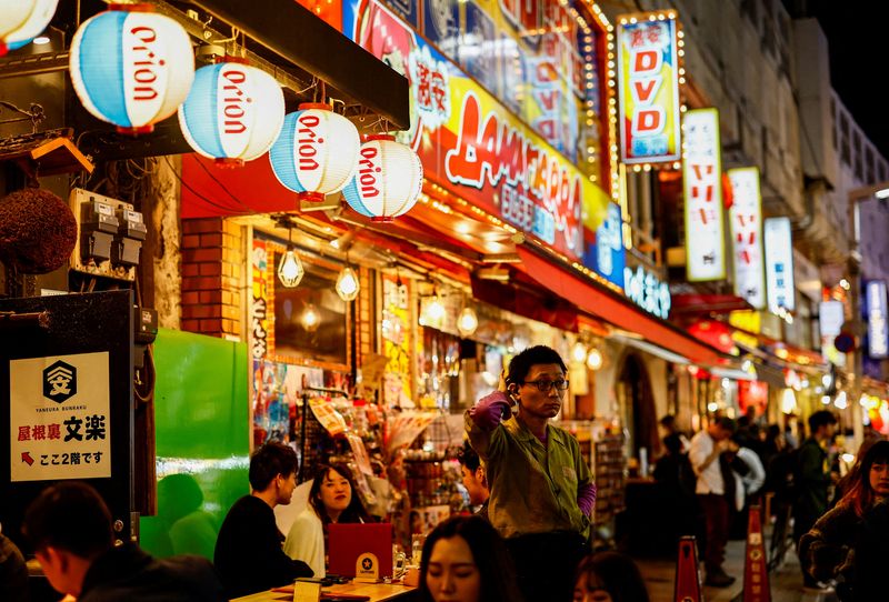 &copy; Reuters. FILE PHOTO: People enjoy drinks and food at izakaya pub restaurants at the Ameyoko shopping district, in Tokyo, Japan February 15, 2024. REUTERS/Issei Kato/File Photo