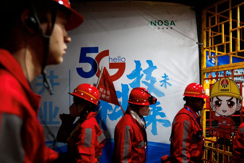 &copy; Reuters. FILE PHOTO: Media reporters walk past a sign of 5G at an underground coalface where Huawei 5G base stations are deployed to support communication and remote control, at Xiaobaodang Coal Mine, during a Huawei-organised media tour, in Shenmu of Yulin city, 