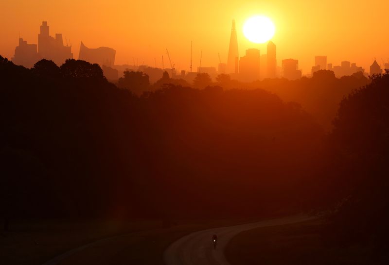 &copy; Reuters. FILE PHOTO: The sun rises above the London skyline as a cyclist trains during hot weather, in Richmond Park, London, Britain, August 12, 2024. REUTERS/Toby Melville/File Photo