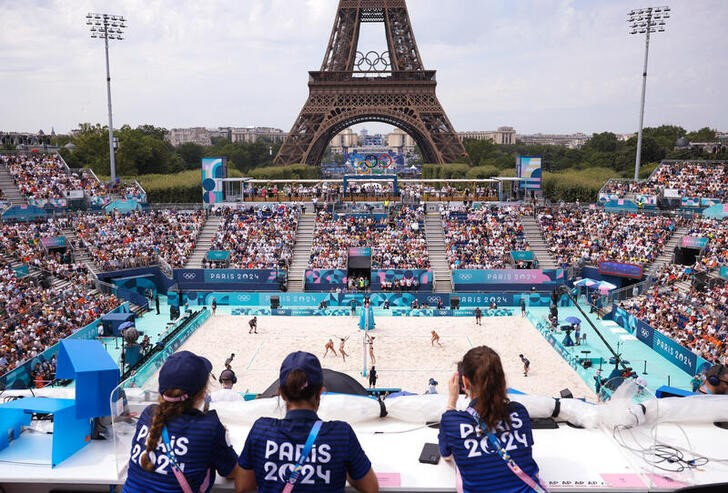 © Reuters. General view of the Eiffel Tower stadium shows Paris 2024 staff watching the match, while the Eiffel Tower and Olympic rings can be seen in the background. REUTERS/Louisa Gouliamaki/file photo