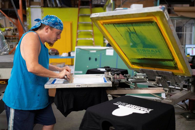 &copy; Reuters. FILE PHOTO: Screen printer Chris Fleury manually screen prints a small run of 20 t-shirts in support of U.S. Vice President Kamala Harris' presidential campaign at the Gloo Factory in Tucson, Arizona, U.S., July 25, 2024.  REUTERS/Rebecca Noble/File Photo