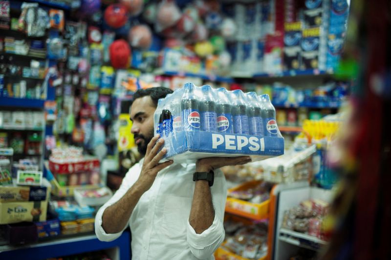 © Reuters. FILE PHOTO: A corner store salesman carries Pepsi drinks as he delivers them to his customer in Isa Town, Bahrain, August 30, 2024. REUTERS/Hamad I Mohammed/File Photo