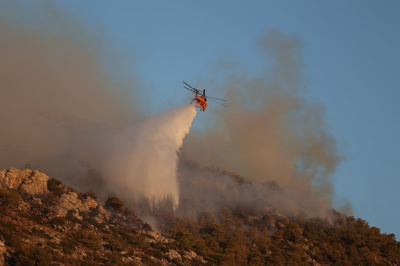 &copy; Reuters. FILE PHOTO: A firefighting helicopter drops water at a resurgence near Nea Makri, east of Athens, Greece, August 13, 2024. REUTERS/Alexandros Avramidis/File Photo