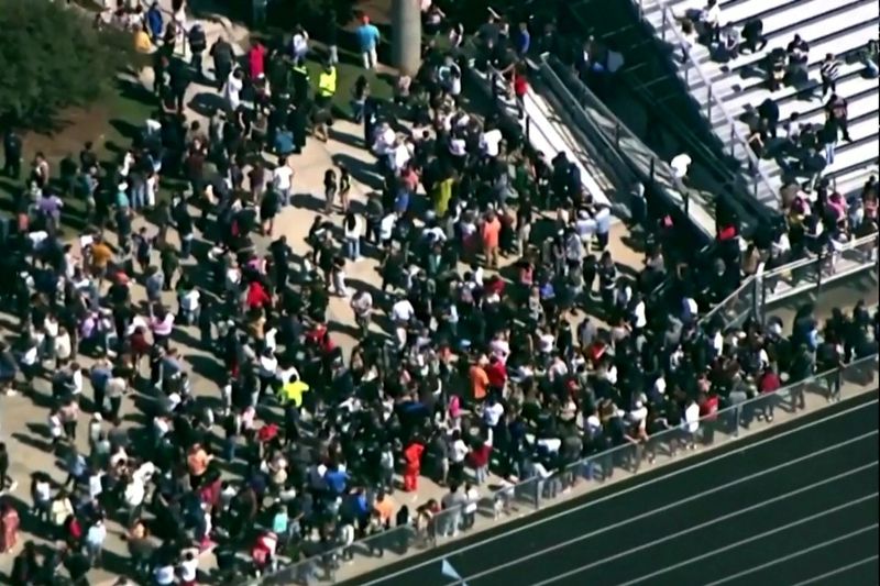 © Reuters. Students and staff gather next to the football field after law enforcement officers responded to a fatal shooting at Apalachee High School in a still image from aerial video in Winder, Georgia, U.S. September 4, 2024.   ABC Affiliate WSB via REUTERS.   