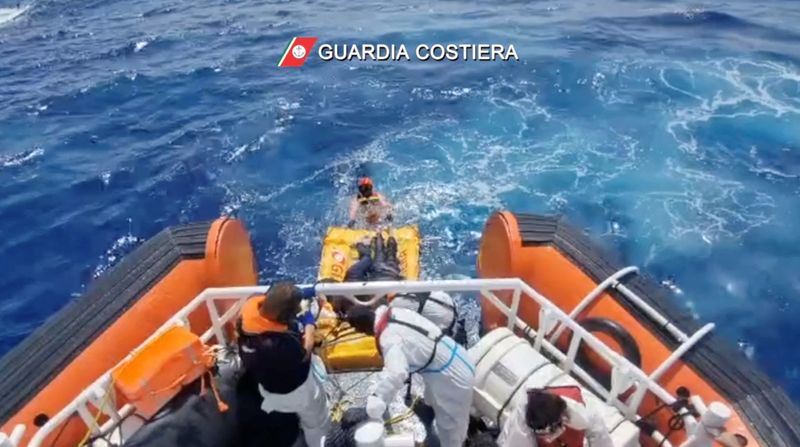 © Reuters. Coast guard members rescue the seven survivors of a boat that had set off from Libya a few days ago, with 28 people on board and shipwrecked near the Sicilian island of Lampedusa, Italy, September 4, 2024, in this screengrab from video. Guardia Costiera/Handout via REUTERS