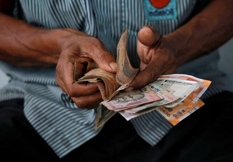 © Reuters. FILE PHOTO: A gas station attendant arranges Indian rupee notes in Kolkata, India August 16, 2018. REUTERS/Rupak De Chowdhuri/File Photo