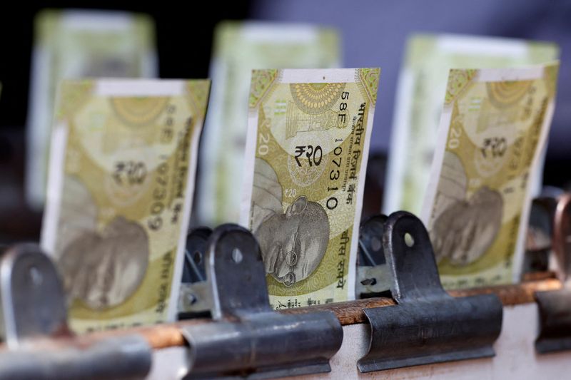 © Reuters. Indian twenty rupee currency notes are displayed at a roadside currency exchange stall in New Delhi, India, May 24, 2024. REUTERS/Priyanshu Singh/File Photo