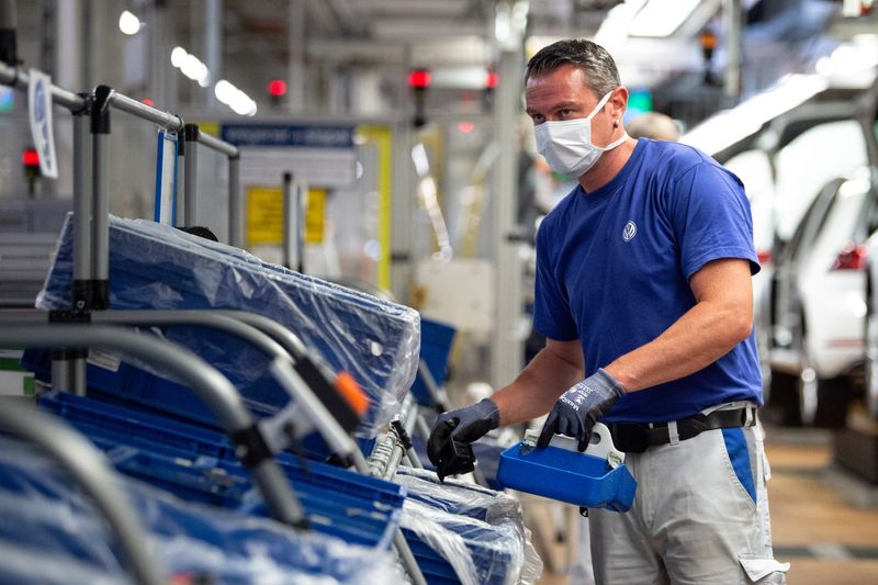 © Reuters. FILE PHOTO: A worker wears a protective mask at the Volkswagen assembly line after VW re-starts Europe's largest car factory after coronavirus shutdown in Wolfsburg, Germany, April 27, 2020. Swen Pfoertner/Pool via REUTERS/File Photo