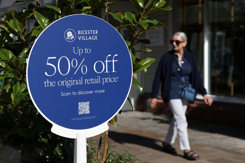 &copy; Reuters. FILE PHOTO: A shopper walks past a sign that says ‘Up to 50% off the original retail price’ at Bicester Village in Oxfordshire, Britain, August 21, 2024. REUTERS/Hollie Adams/File Photo