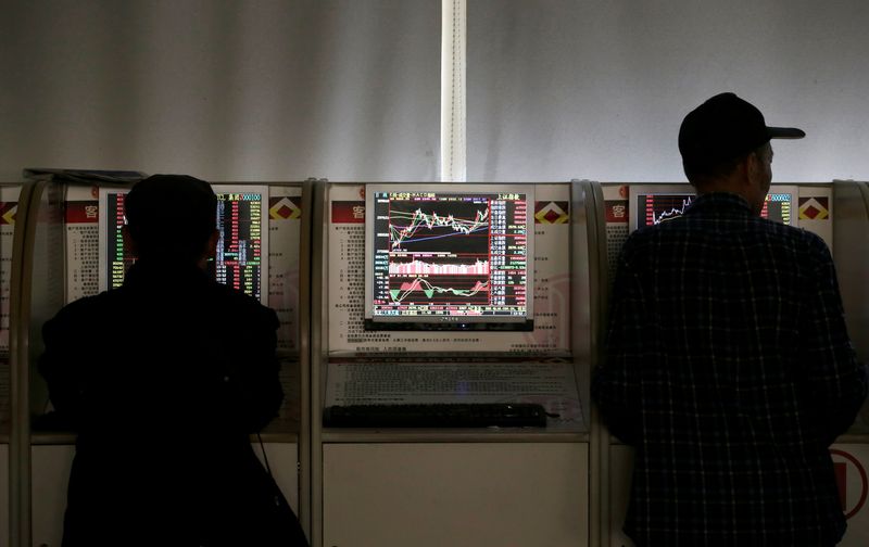 © Reuters. Investors check stock prices at a brokerage office in Beijing, China, January 2, 2020. REUTERS/Jason Lee/File Photo