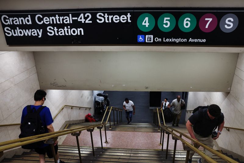 &copy; Reuters. FILE PHOTO: People exit the Grand Central-42 Street subway station as a man sits with his belongings at the bottom of the stairs in New York City, U.S., July 22, 2024. REUTERS/Shannon Stapleton/File Photo