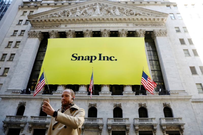 &copy; Reuters. FILE PHOTO: A man takes a photograph of the front of the New York Stock Exchange (NYSE) with a Snap Inc. logo hung on the front of it in New York, U.S., March 2, 2017. REUTERS/Lucas Jackson/File Photo