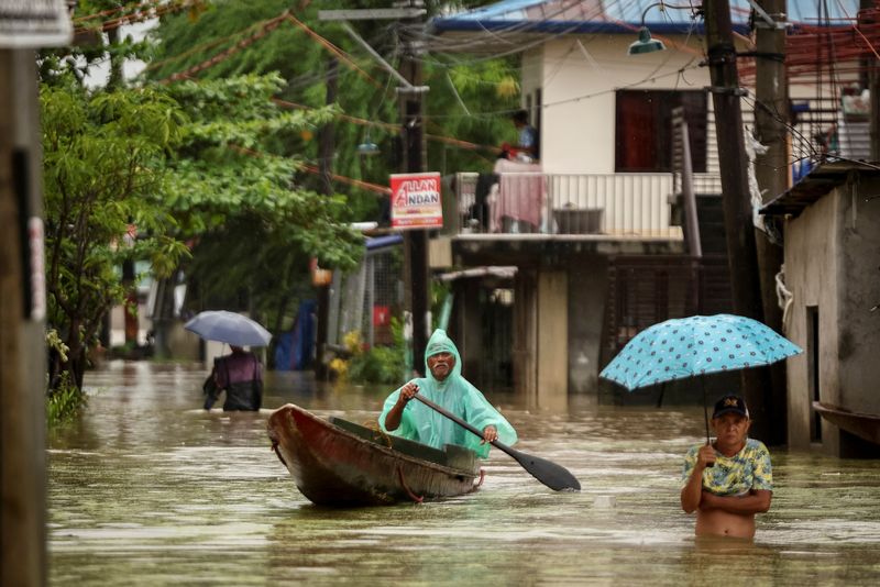 &copy; Reuters. Pessoas navegam pelas águas de enchente provocada pelas fortes chuvas durante passagem do tufão Yagi nas Filipinasn05/09/2024 REUTERS/Eloisa Lopez