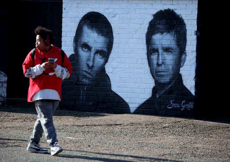 &copy; Reuters. Homem passa em frente a mural com imagem de Liam e Noel Gallagher, da banda Oasis, em Whitefield, perto de Manchester, no Reino Unidon31/08/2024 REUTERS/Phil Noble