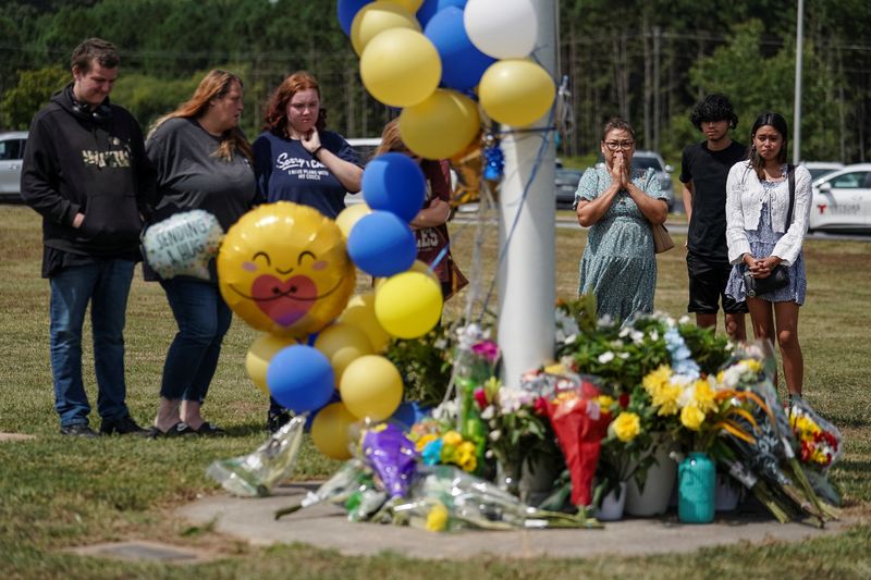 &copy; Reuters. A woman holds her hands together in prayer after laying flowers at the site of a makeshift memorial at Apalachee High School the day after a fatal shooting left four dead in Winder, Georgia, U.S. September 5, 2024. REUTERS/Elijah Nouvelage