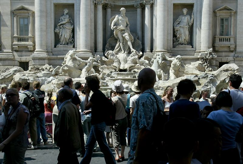 &copy; Reuters. Turistas em frente à mundialmente famosa fonte Fontana di Trevi, em Roman11/07/2003nREUTERS/Tony Gentilen