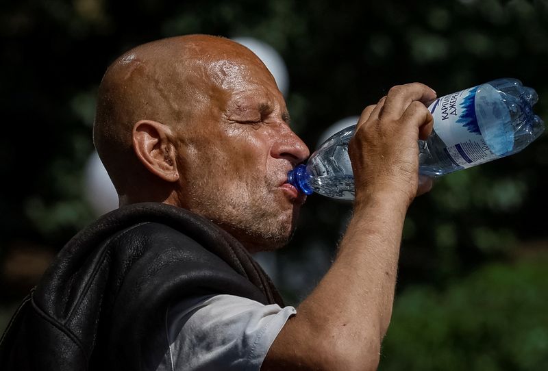 © Reuters. FILE PHOTO: A man drinks water on the street during an abnormally hot summer day, amid Russia's attack on Ukraine, in central Kyiv, Ukraine July 15, 2024. REUTERS/Gleb Garanich/File Photo