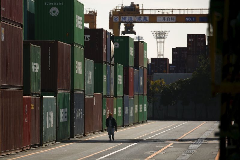 &copy; Reuters. FILE PHOTO: A worker walks between shipping containers at a port in Tokyo, Japan,  February 18, 2016. REUTERS/Thomas Peter/File Photo