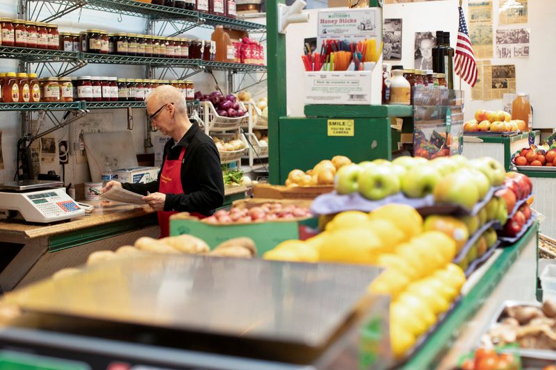 &copy; Reuters. FILE PHOTO: Thomas Calomiris looks over the books at his produce stand in Eastern Market in Washington, U.S., August 14, 2024. REUTERS/Kaylee Greenlee Beal/File Photo