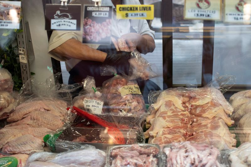 © Reuters. FILE PHOTO: A person packages poultry for a customer at Eastern Market in Washington, U.S., August 14, 2024. REUTERS/Kaylee Greenlee Beal/File Photo