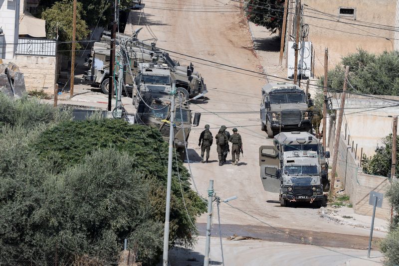 &copy; Reuters. Le forze di sicurezza israeliane camminano accanto a veicoli blindati durante un raid israeliano a Jenin durante un raid israeliano, a Jenin, nella Cisgiordania occupata da Israele, 3 settembre 2024. REUTERS/Raneen Sawafta