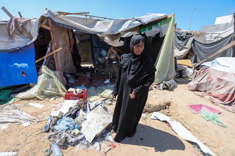 © Reuters. Displaced woman Iqbal Al-Zeidi stands in front of her tent which was torn by an Israeli strike, on the courtyard of Al-Aqsa Martyrs hospital, amid the Israel-Hamas conflict, in Deir Al-Balah in the central Gaza Strip, September 5, 2024. REUTERS/Ramadan Abed/File Photo