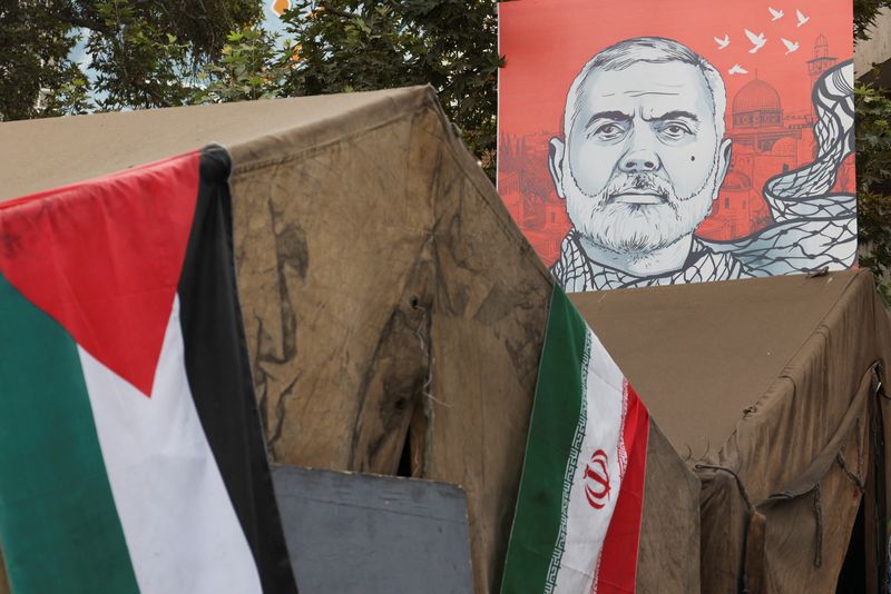 © Reuters. FILE PHOTO: A banner with a picture of late Hamas leader Ismail Haniyeh is displayed next to the Iran and Palestinian flags in a street in Tehran, Iran, August 12, 2024. Majid Asgaripour/WANA (West Asia News Agency) via REUTERS/File Photo