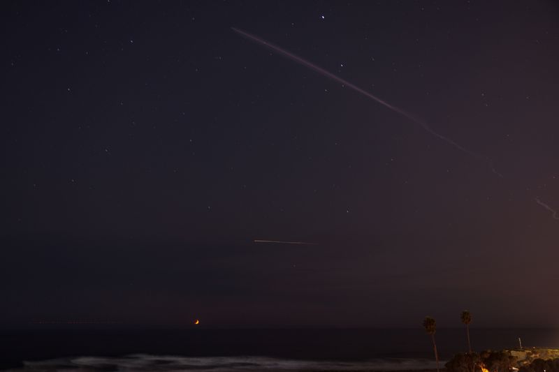 © Reuters. The launch of a SpaceX Falcon 9 rocket from Vandenberg Space Force Base carrying the NROL-113 mission into orbit can be seen over the ocean and high in the night sky in this time lapse shot from Encinitas, California, U.S., September 5, 2024. REUTERS/ Mike Blake