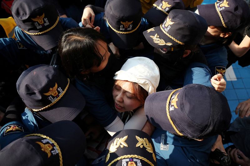 © Reuters. A naked climate activist is surrounded by policewomen while marching in Gangnam district during a climate justice rally in central Seoul, South Korea, September 7, 2024. REUTERS/Kim Hong-Ji/File Photo