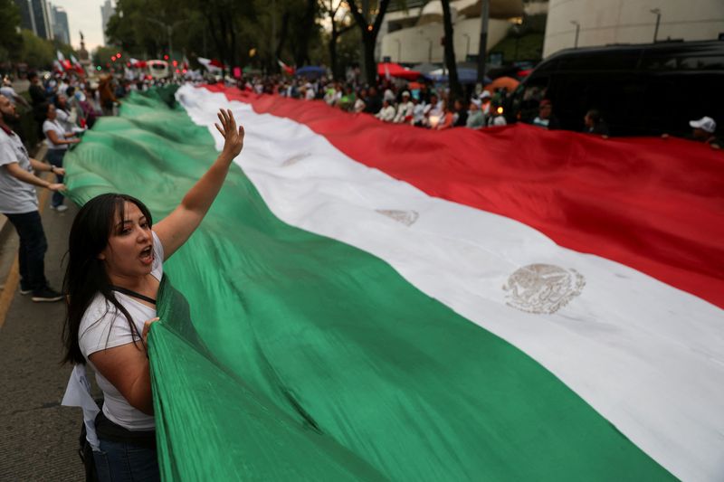 © Reuters. Demonstrators display a large Mexico flag during a protest against the controversial overhaul of the country's judiciary, which would usher in a new era of elections for all judges, outside the Senate building in Mexico City, Mexico September 8, 2024. REUTERS/Luis Cortes