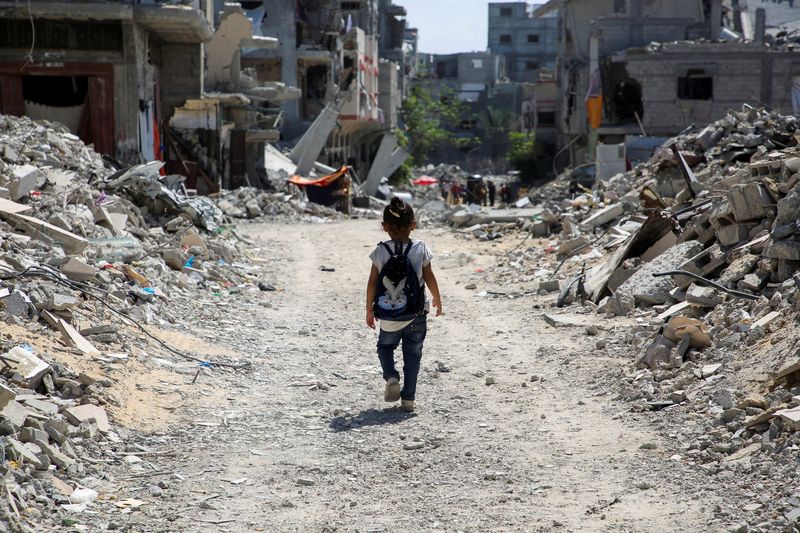 © Reuters. A Palestinian student walks between the rubble, as war disrupts a new school year, amid the Israel-Hamas conflict, in Khan Younis, in the southern Gaza Strip, September 4, 2024. REUTERS/Hatem Khaled/File Photo